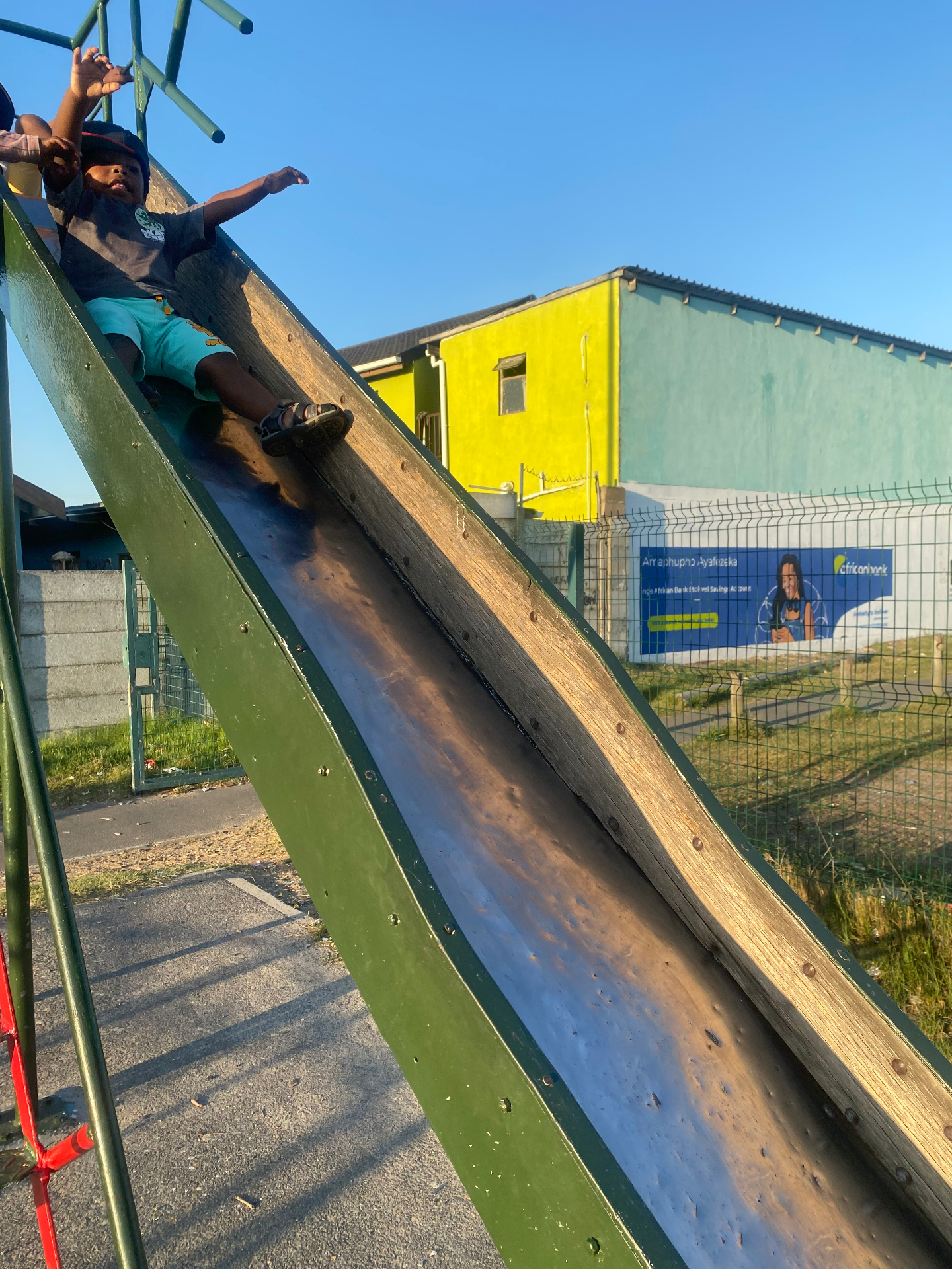 Young boy enjoying the playground slide