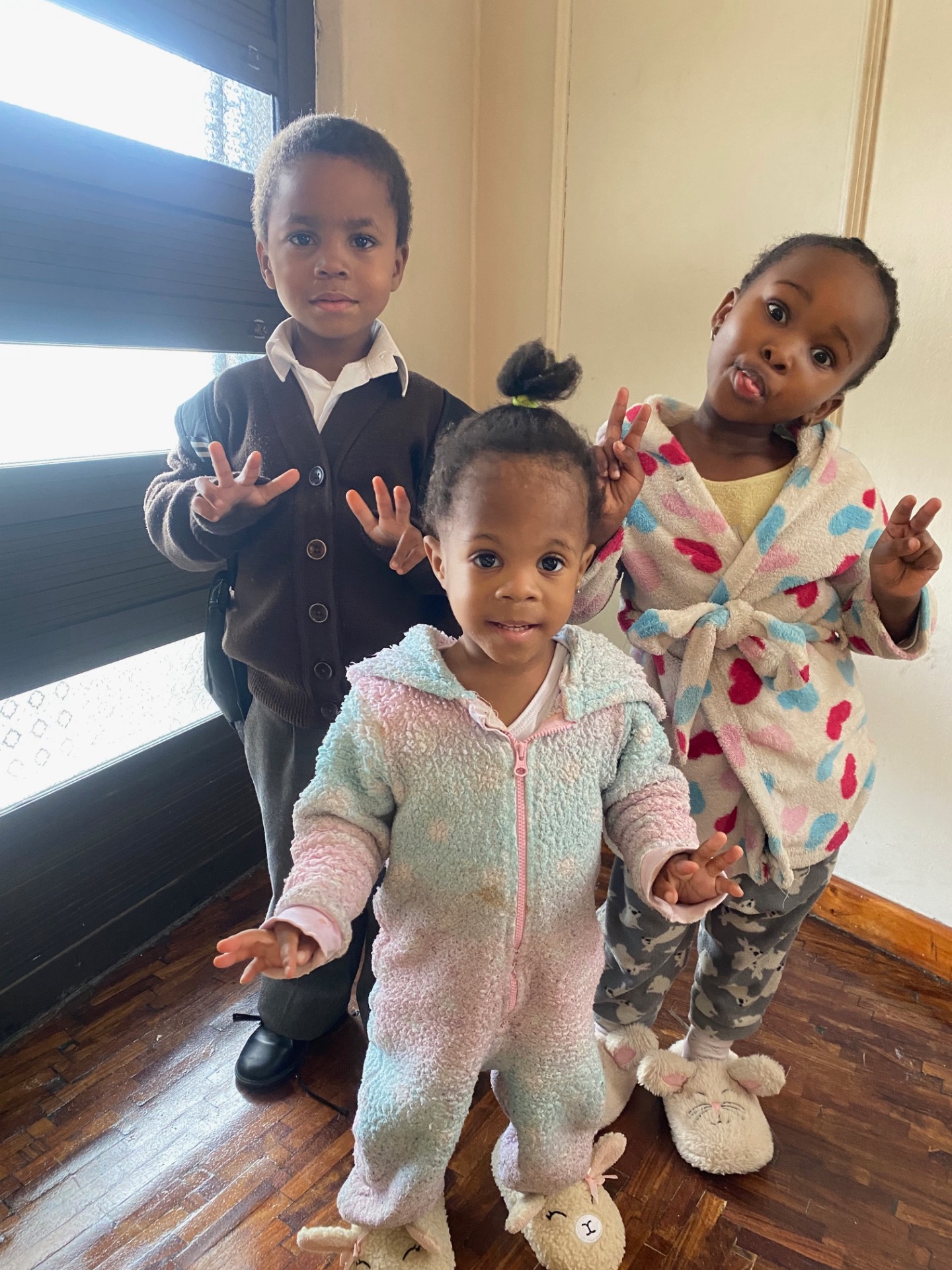 Children smiling and showing peace signs